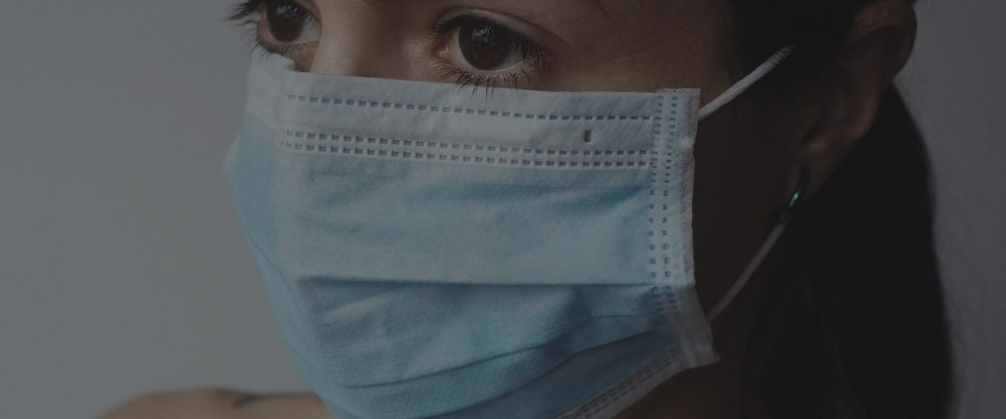 COVID-19 woman wearing blue surgical mask
